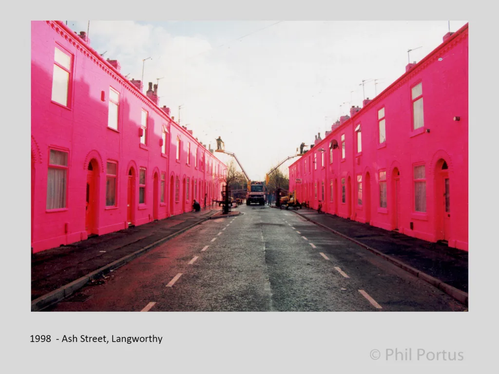 Rows of houses painted a bright pink line both sides of a narrow street.