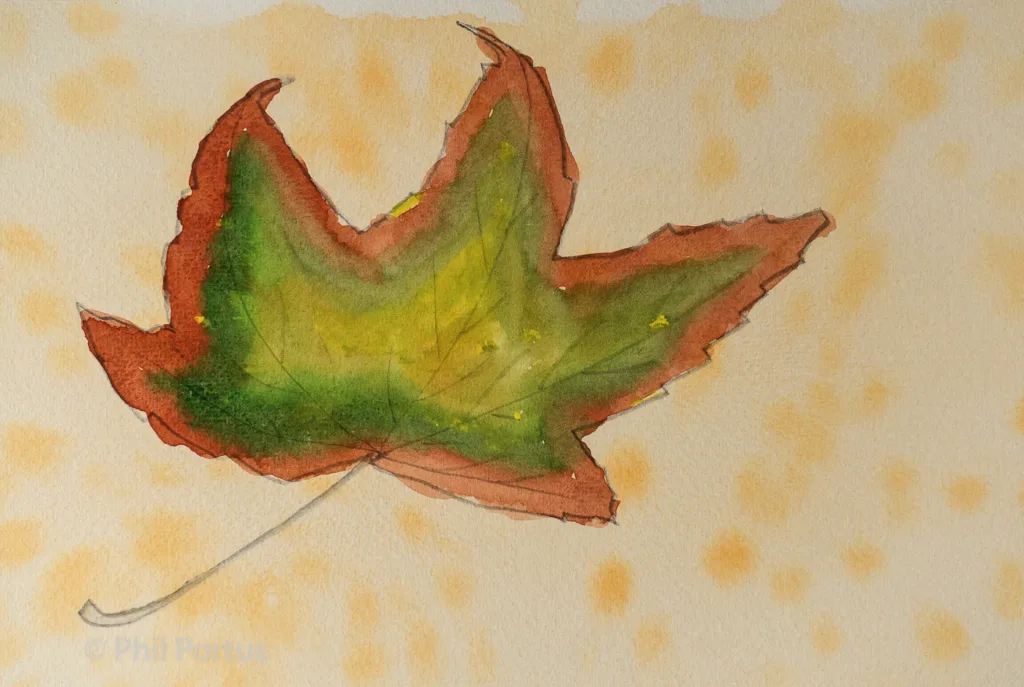 A watercolor painting shows a leaf with orange, green, and brown hues against a lightly textured background.