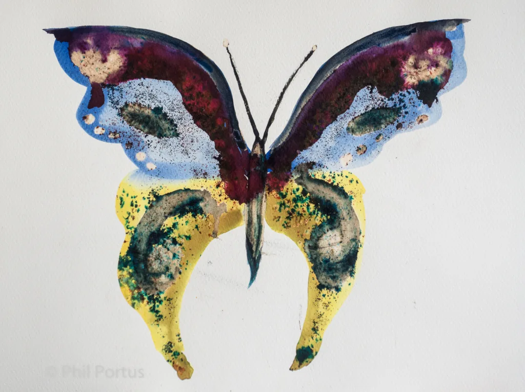 A watercolor painting of a butterfly with purple, blue, yellow, and brown hues is centered on white paper.