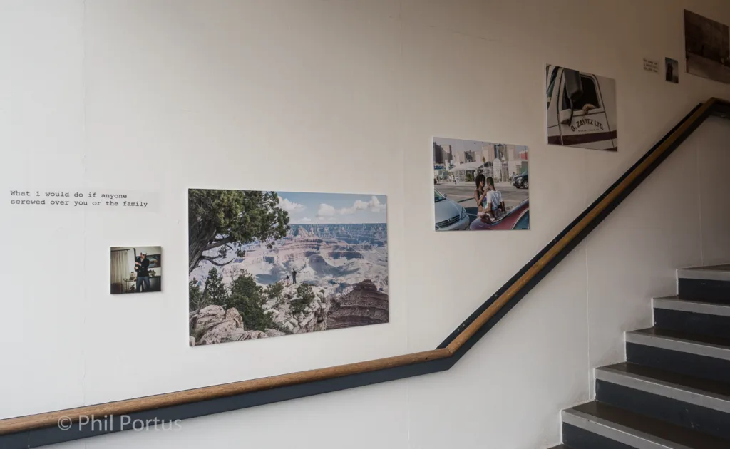 A wall with several framed prints and a handwritten note is visible alongside a staircase.