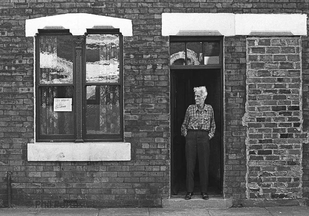 Mr Joe Hunter on Nashville Street with sign "This house is occupied" during terraced house clearance. Ordsall, Salford, UK, 1978